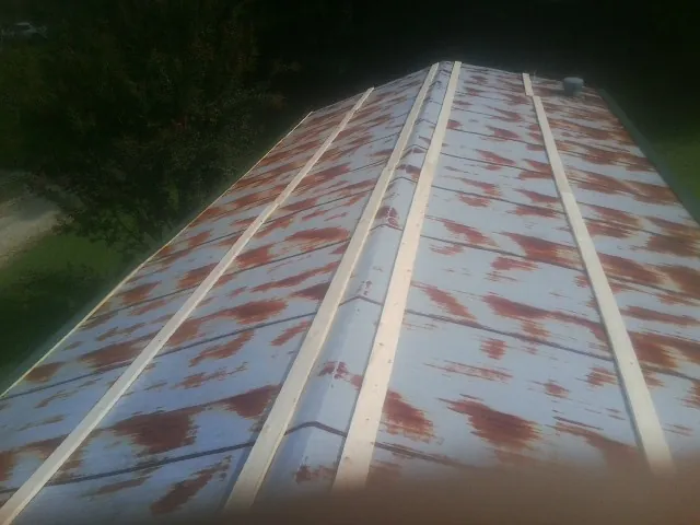Rusted metal roof panels with new wood purlins before replacement — Storm Damage Roof Repair in Latham by Roofing Brothers