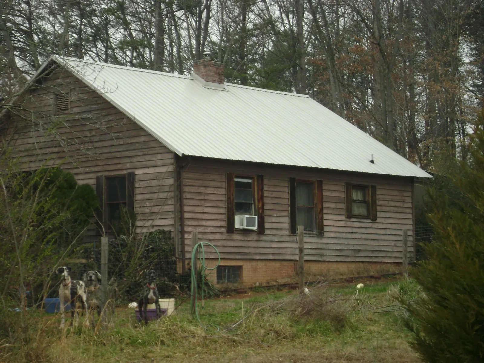 White metal roof on an old wood sided farmhouse, from a Metal Roof Installation job in Latham